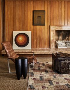 Interior shot of the Surf Shack's living room, photographed by The Ingalls, featuring a cozy arrangement with natural light pouring through large windows and mid-century modern furniture.