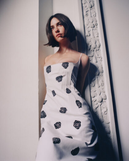 Photograph of Gracie Abrams in a white dress with black flowers, captured by Heather Hazzan for Billboard. 